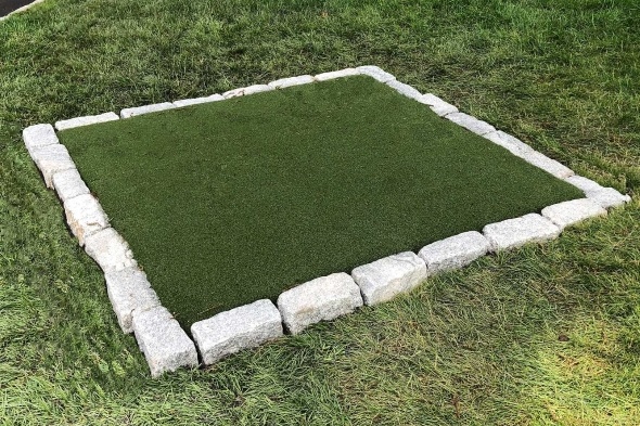 Phoenix Tee box made of synthetic grass surrounded by stone border