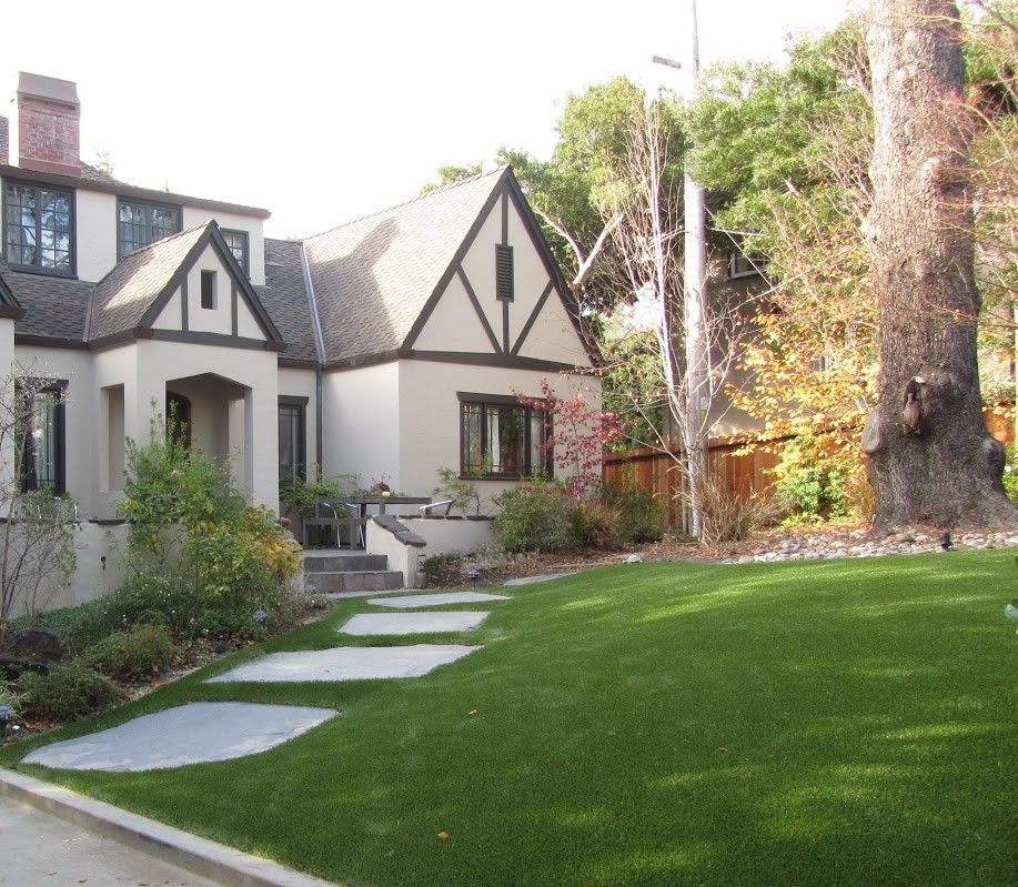 artificial turf in front of a house with tree