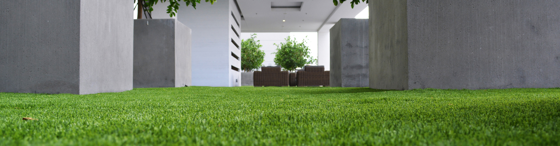 Artificial grass installation in a commercial courtyard with contemporary architecture and outdoor furniture