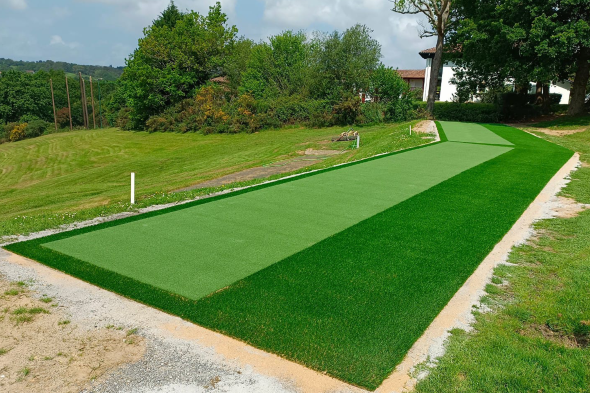 Phoenix Outdoor tee line consisting of one continuous green synthetic grass strip surrounded by trees