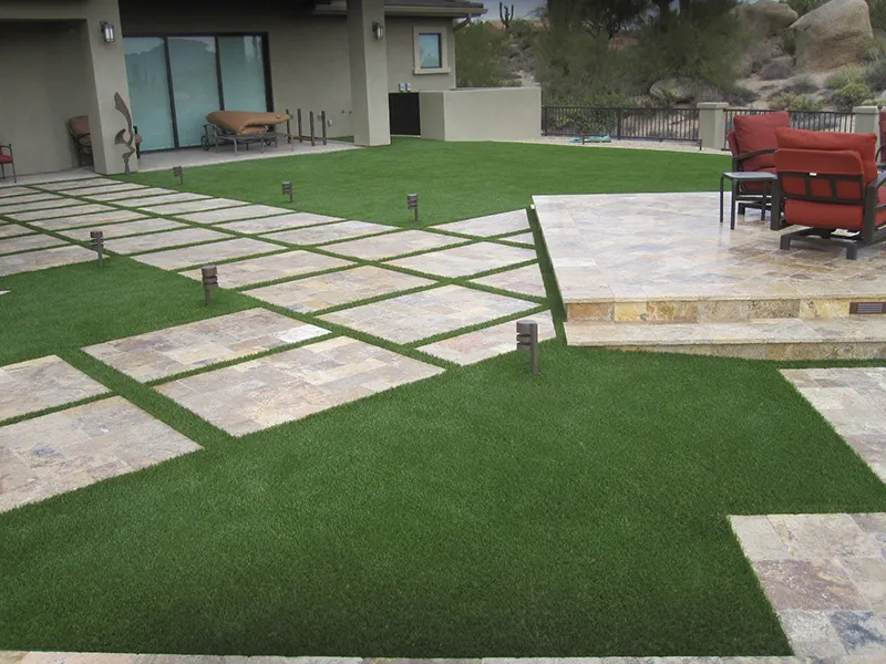 artificial turf in a front yard with a house and pavers