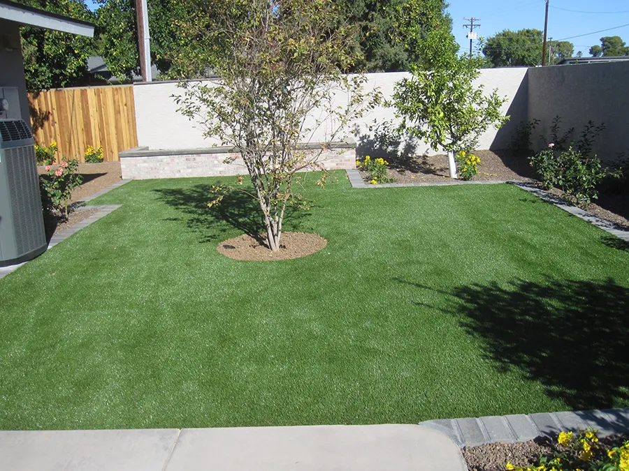 artificial turf in a backyard with a tree