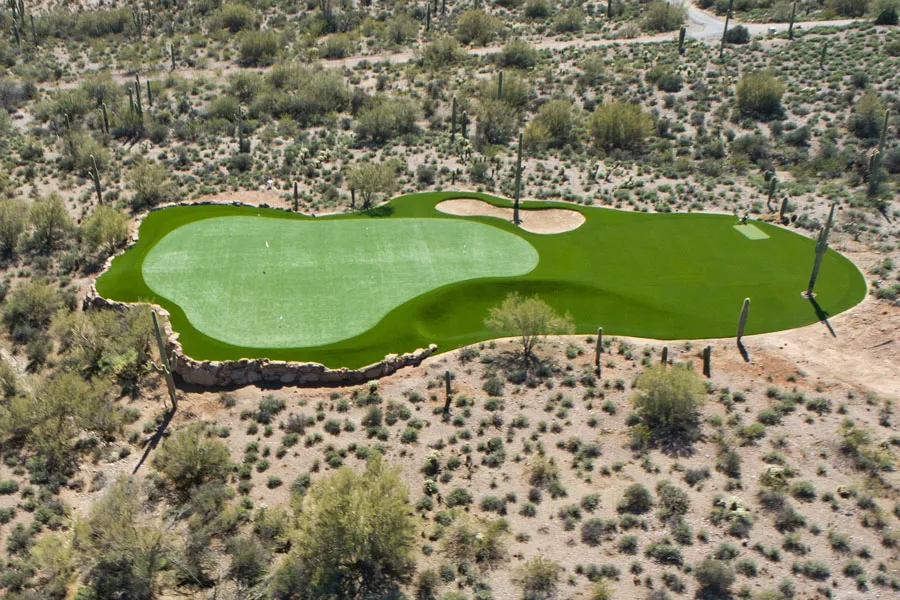 a drone shot of a putting green in the desert
