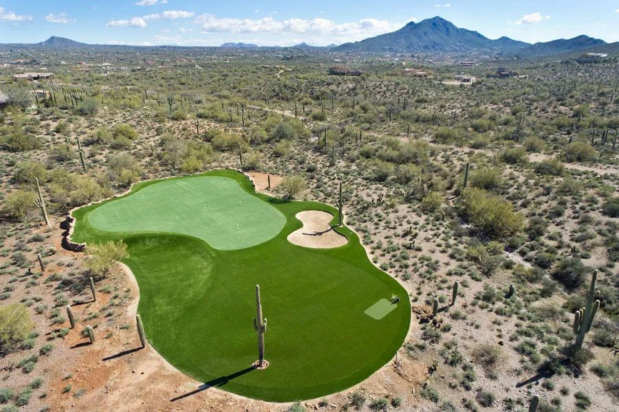 a drone shot of a putting green in the desert