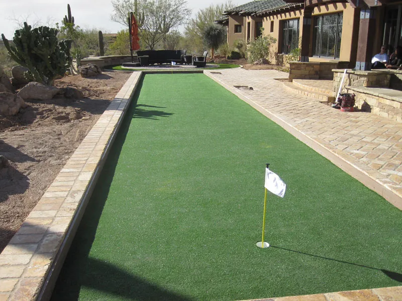 a narrow putting green in a backyard