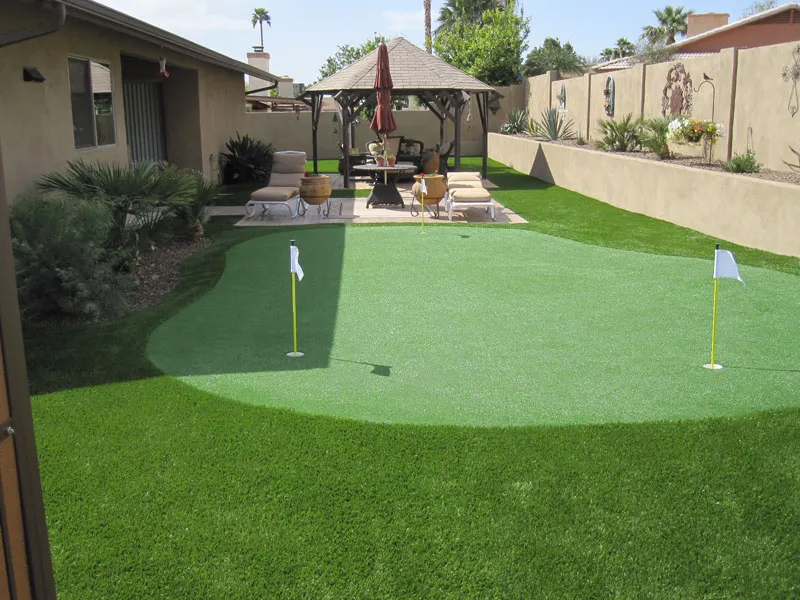 a putting green in a backyard near a house
