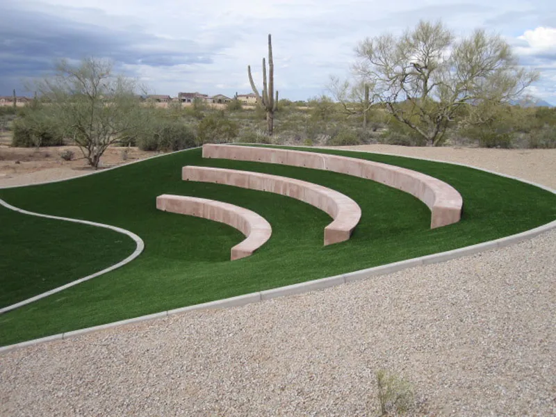 artificial turf on a hill with long concrete benches