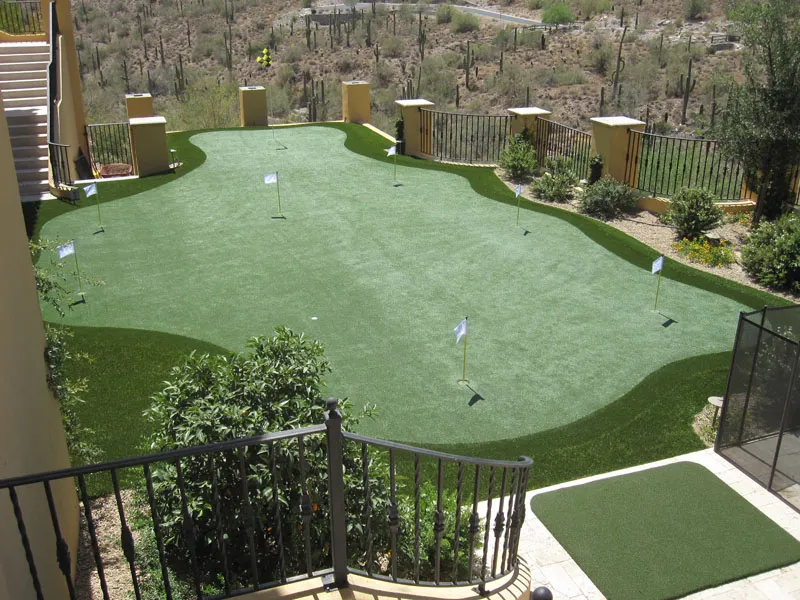 a putting green in a fenced area in the desert