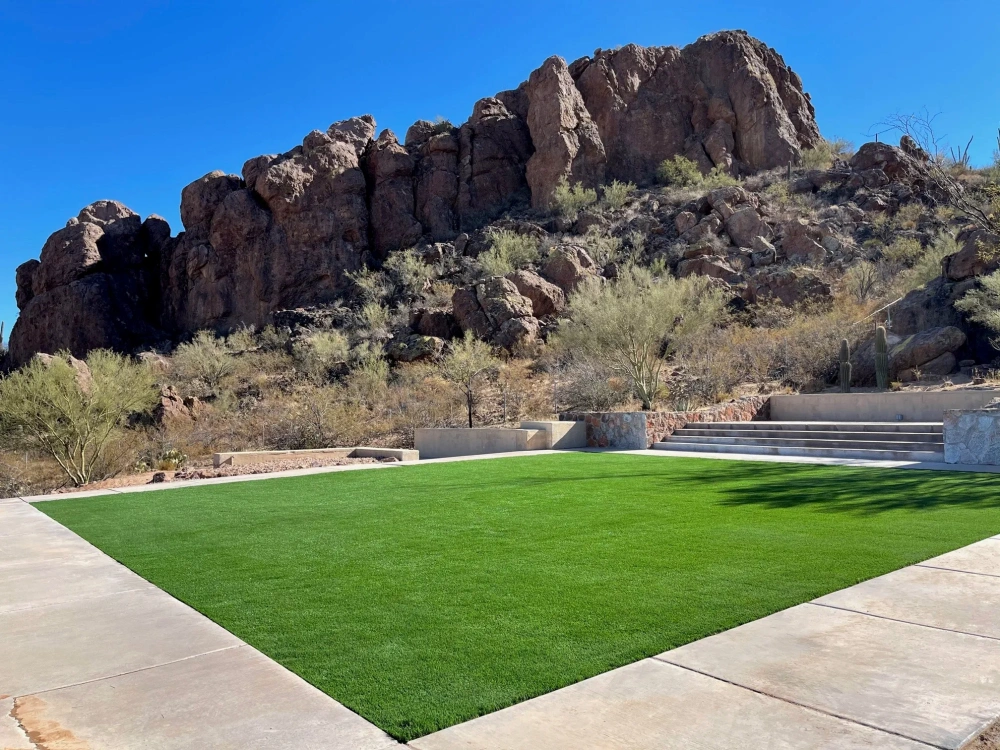 artificial turf in a backyard with a hill in the background